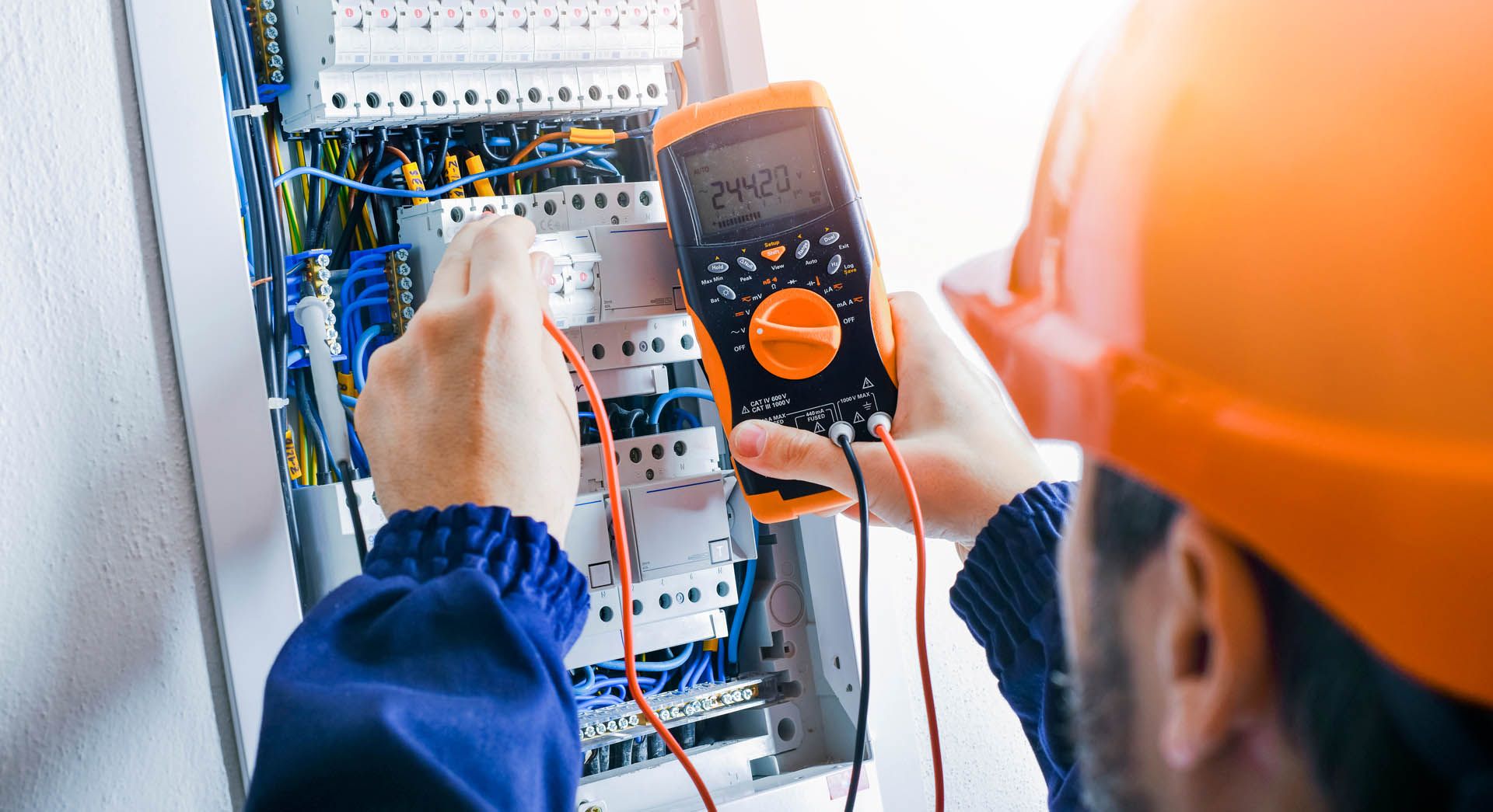 Elektriker misst Strom an einem Schaltkasten